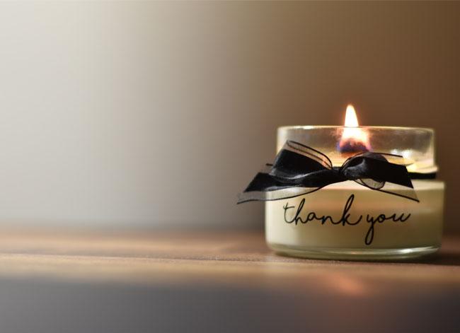 Photo of a lit candle with the words "Thank you" on the front