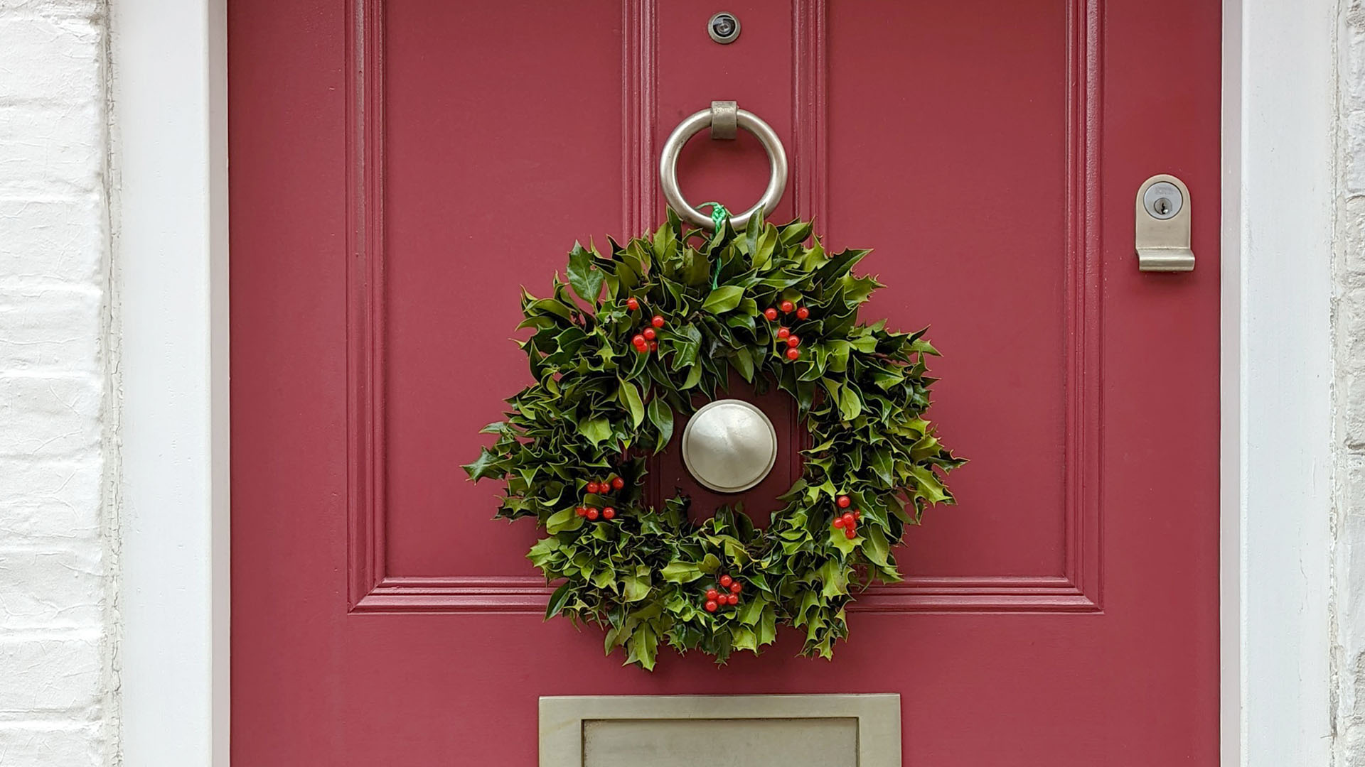 Photo of a red front door with a Christmas wreath